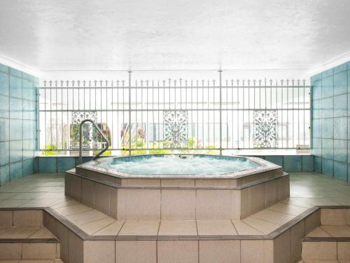 - un bain à remous dans une chambre avec fenêtre dans l'établissement BreakFree Beachpoint, à Gold Coast