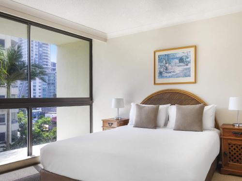 ein Schlafzimmer mit einem weißen Bett und einem großen Fenster in der Unterkunft BreakFree Imperial Surf in Gold Coast