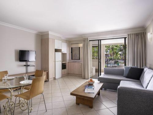 a living room with a couch and a table at Mantra Heritage in Port Douglas
