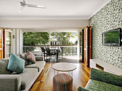 a living room with a couch and a table at Mantra on the Inlet in Port Douglas