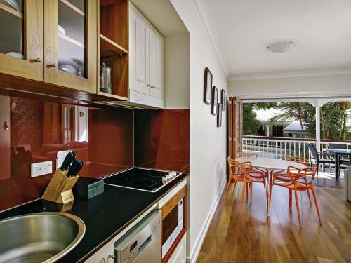 a kitchen with a sink and a table with chairs at Mantra on the Inlet in Port Douglas