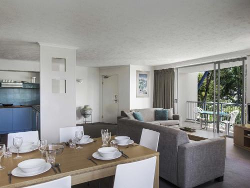 a living room with a table and a couch at BreakFree Diamond Beach in Gold Coast