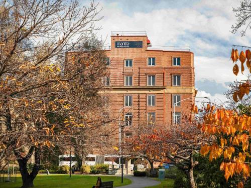 a large brick building with a sign on it at Mantra One Sandy Bay Road in Hobart