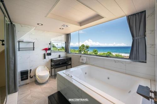 ein Badezimmer mit großer Badewanne mit Blick auf das Meer in der Unterkunft 小琉球暮光停琉海景包棟民宿 in Xiaoliuqiu