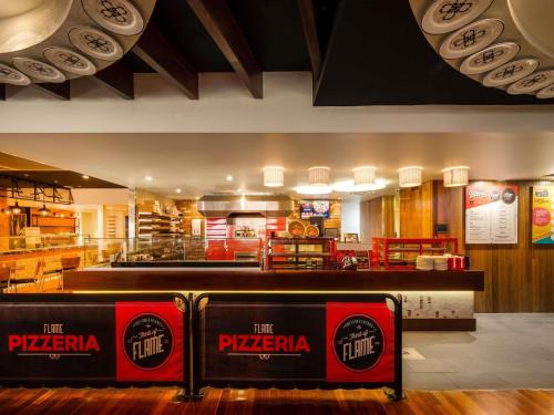 Um restaurante de fast food com uma pizzaria ao fundo. em Mantra Twin Towns em Tweed Heads