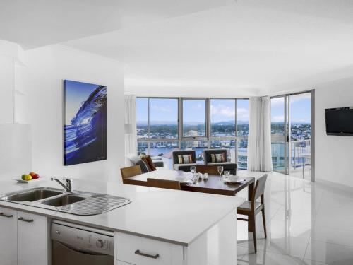 a kitchen and dining room with a view of the city at Mantra Sun City in Gold Coast