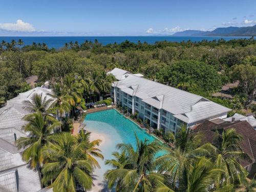 an aerial view of a resort with a pool and palm trees at Peppers Beach Club in Port Douglas
