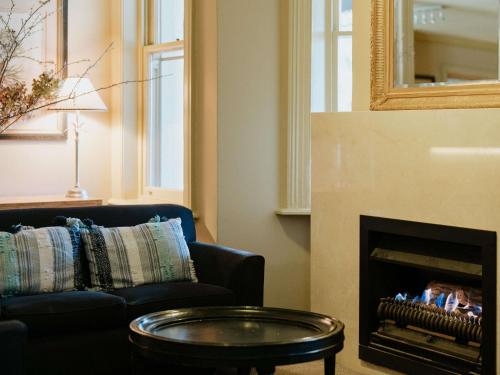 uma sala de estar com sofá e lareira em Peppers Craigieburn Resort em Bowral
