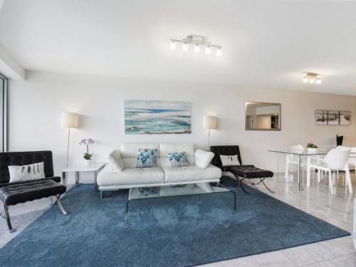 a living room with a white couch and a table at Mantra Sirocco in Mooloolaba