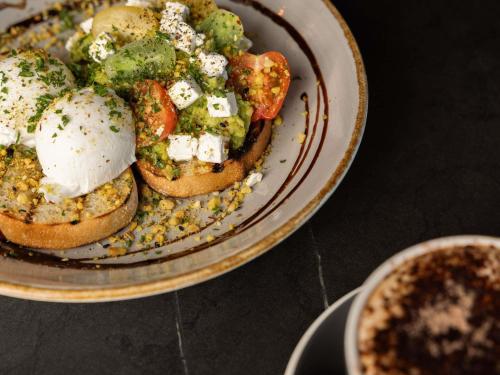 een bord met brood en groenten op een tafel bij Peppers Clearwater Resort in Christchurch