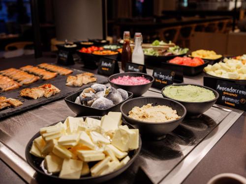 um bufê cheio de diferentes tipos de comida em uma mesa em Novotel Hamburg Central Station em Hamburgo