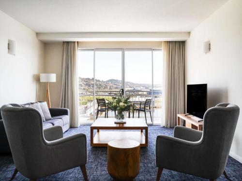 a living room with a couch and chairs and a table at Peppers Seaport Launceston in Launceston