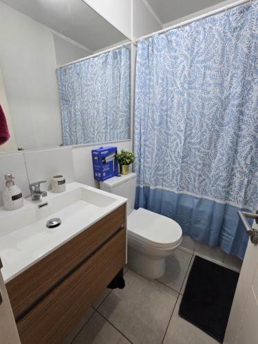 a bathroom with a toilet and a sink at Rancagua Lujo y comodidad Depto con Piscina y Estacionamiento in Rancagua