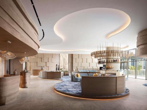 una hall con divano e lampadario a braccio di Novotel Sihanoukville Holiday Resort a Sihanoukville