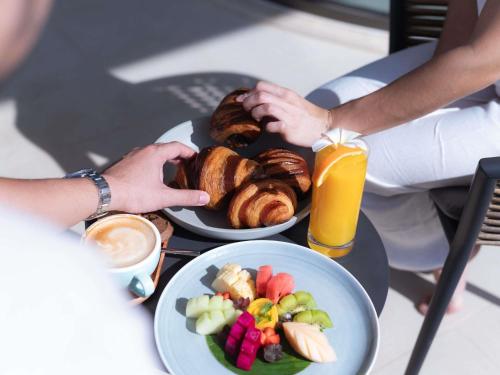 Una mesa cubierta con platos de comida y un plato de pasteles. en Novotel Sihanoukville Holiday Resort, en Sihanoukville