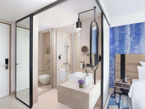 a bathroom with a sink and a toilet and a shower at Novotel New Delhi City Centre in New Delhi