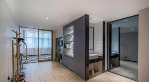 une salle de bain avec un lavabo et un grand miroir dans l'établissement City Comfort Premier Hotel Nanning Guangxi University Zoo Metro Station, à Nanning