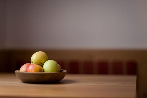 a bowl of apples on a wooden table at Hotel Jager Hans in San Martino