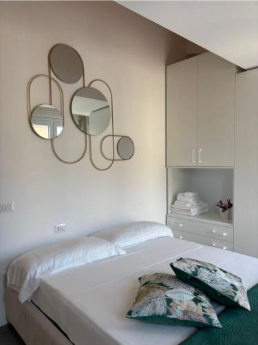 a bedroom with a bed with two mirrors on the wall at NALI Apartment 2 in Civitanova Marche