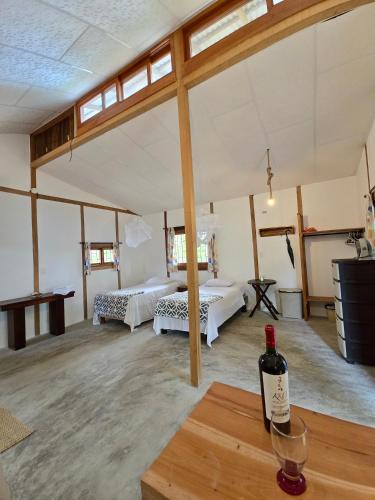 a room with two beds and a bottle of wine on a table at La posada de Mary in Montañita