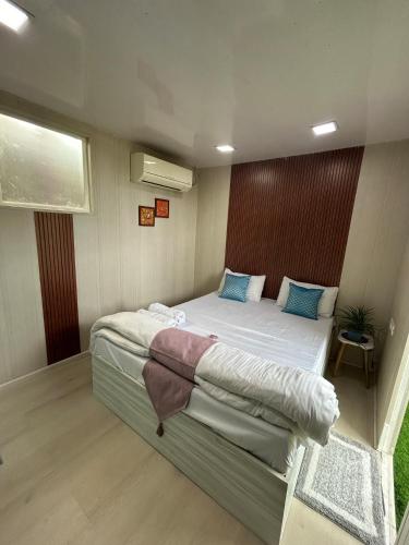 a bedroom with a large white bed with blue pillows at Cosy and Comfortable Cottage in South Delhi in New Delhi
