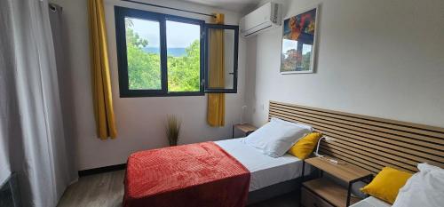 een kleine slaapkamer met een bed en een raam bij Villa Rosie in Sainte-Rose