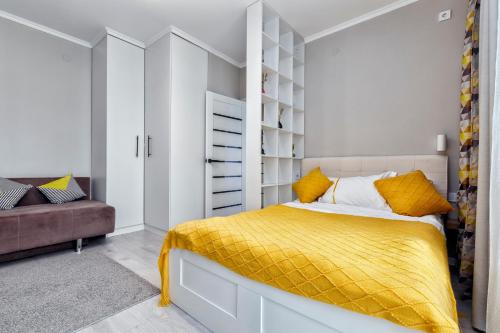 1 dormitorio con 1 cama con manta amarilla en Freedom, en Astana