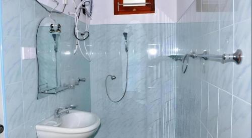 a bathroom with a shower with a toilet and a mirror at Hotel Tangoreef in Tangalle