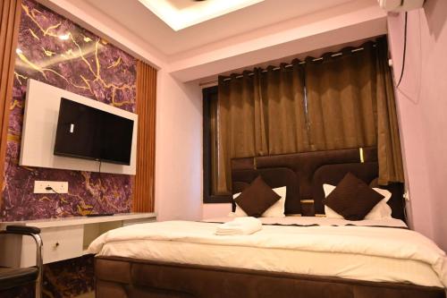 a bedroom with a bed and a tv on a wall at Shivay family home stay in Varanasi
