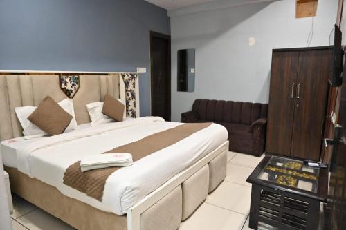 a bedroom with a large bed and a couch at Shivay family home stay in Varanasi