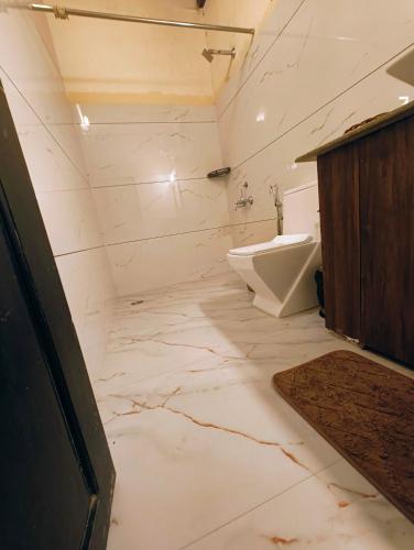 a white bathroom with a sink and a toilet at The Road's End in Gonikoppal