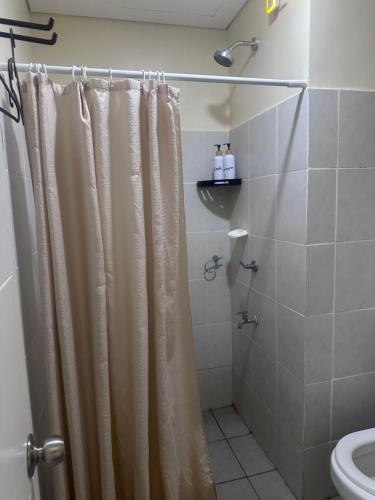 ein Bad mit einem Duschvorhang und einem WC in der Unterkunft Northwoods Place Condominium Unit1026 in Mandaue City