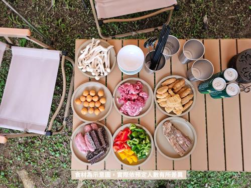 a table filled with bowls of food on the grass at 苗栗南庄 春友彩虹民宿SpringYU in Nanzhuang