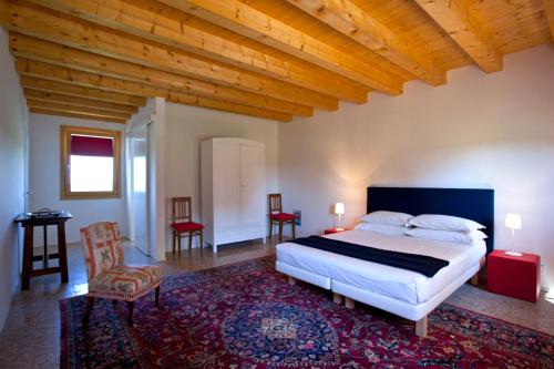 a bedroom with a large bed and a wooden ceiling at Ca' Adami in Brussa