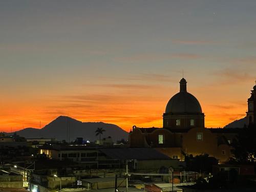 a sunset over a city with a church and mountains at DCalli Next to the Alameda, terrace and confort in Orizaba