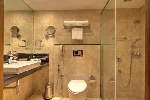 a bathroom with a shower and a toilet and a sink at Dolphin Hotel in Visakhapatnam
