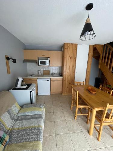 une cuisine et une salle à manger avec une table et des chaises dans l'établissement Duplex dans chalet au coeur de la station, à Réallon