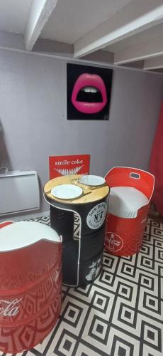 een kamer met een tafel en twee rode stoelen bij studio pop art in Saint-Philbert-sur-Risle