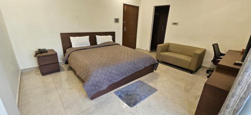 une chambre avec un lit et une chaise dans l'établissement Gachibowli, Santoshi Krupa, à Hyderabad