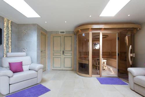 a living room with two white couches and a glass wall at Villa sur Golf Opio Valbonne in Opio