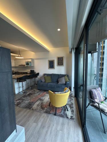 sala de estar con sofá azul y silla amarilla en Adamant Toreo, en Tijuana