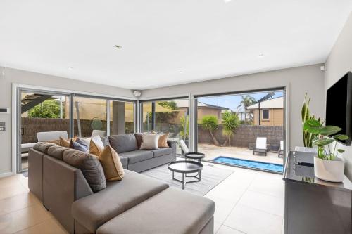 un soggiorno con un divano e un tavolo di Manna Heaven Luxury Coastal Retreat with Pool a Torquay