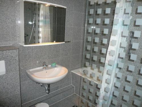 a bathroom with a sink and a mirror at Hotel-Restaurant Nord-Stuv in Cuxhaven