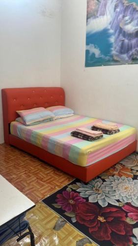 a bedroom with a bed with a colorful blanket at HOMESTAY CIK MUNAH in Taiping