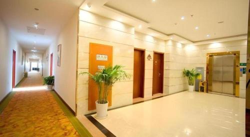 a hallway with potted plants in a building at GreeTree Inn Suzhou Industrial Jinji Lake Xinhujie Gaojiaoqu in Suzhou