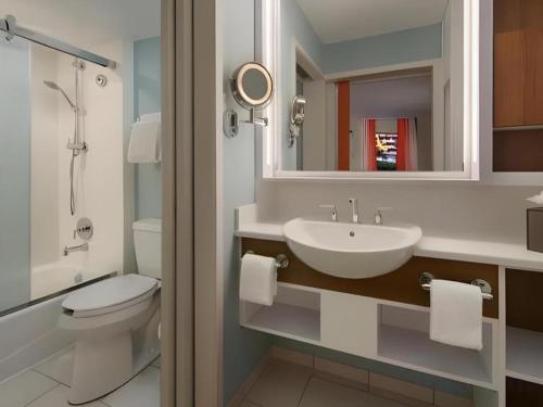 a bathroom with a sink and a toilet and a mirror at Disney's Pop Century Resort in Orlando