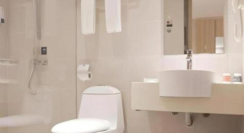 ein weißes Badezimmer mit Toilette und Waschbecken in der Unterkunft City Comfort Inn Hengyang Dayang Department Lianhu Plaza in Hengyang