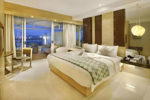 a bedroom with a large bed and a living room at The Rinra in Tanjungbunga