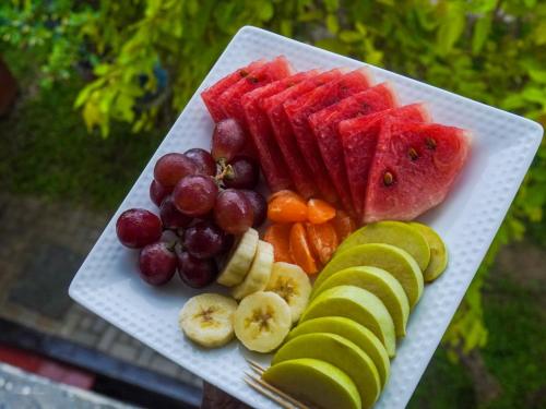 a plate of fruit and vegetables on a table at Difference Rajarata Hotel in Anuradhapura