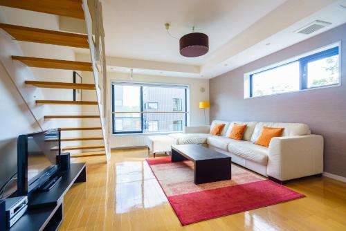 Una sala de estar con un sofá y un televisor en Powder Haven, en Kutchan